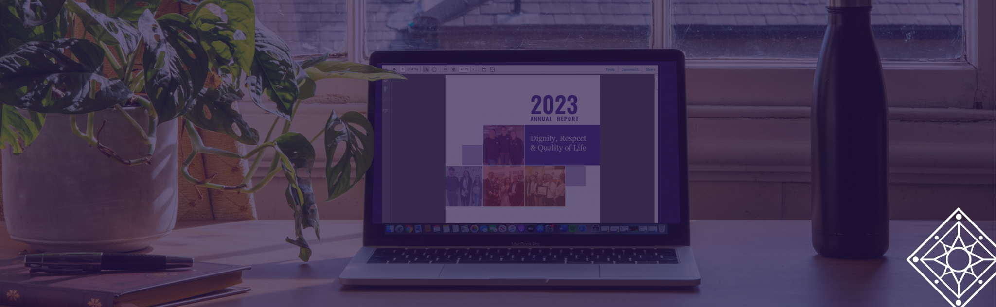 Laptop sits open on a desk, with the cover page of the 2023 Annual Report open on screen.